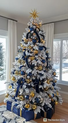 a blue and gold christmas tree with presents under it