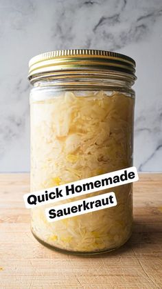 a jar filled with sauerkraut sitting on top of a wooden table