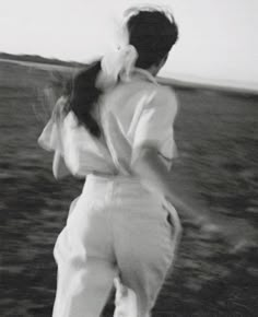 black and white photograph of a woman walking on the beach