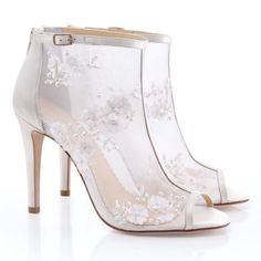 a white high heeled shoe with flowers on the side