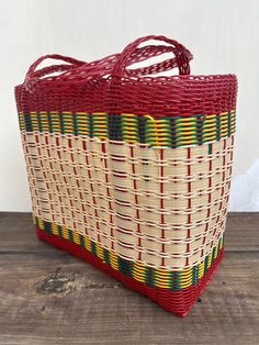 a red and yellow basket sitting on top of a wooden table