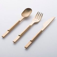 three forks and two spoons on a white surface