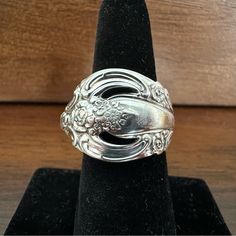 a silver ring sitting on top of a black velvet stand