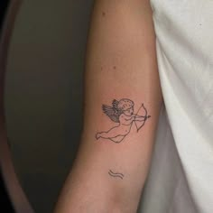 a small cupid tattoo on the arm