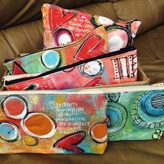 three colorful bags sitting on top of a couch