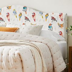 a white bed topped with lots of pillows next to a night stand and nightstands