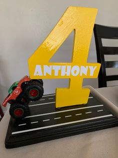 a toy truck is sitting on top of a table with the number four in front of it