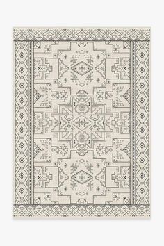 a beige and black rug with an intricate design on the bottom, in front of a white background