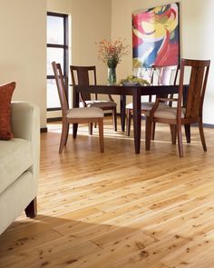 a living room filled with furniture and a painting on the wall over a wooden table