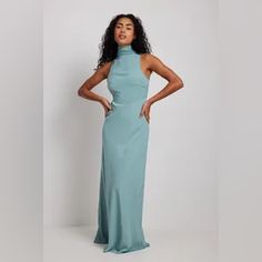 This Maxi Dress Features A High Neck With A Wide Self-Tie Knot At The Back Of The Neck, A Sleeveless Design, An Open Back, A Side Zipper Closure, A Flowy Fit And A Soft Material. This Maxi Dress Comes In Dark Blue. Materials: Shell: 55% Recycled Polyester, 45% Polyester. Lining: 100% Polyester. Fitted Maxi-length Halter Bridesmaid Dress, Blue Fitted Halter Neck Maxi Dress, Fitted Maxi Length Halter Bridesmaid Dress, Fitted Maxi Length Halter Dress For Bridesmaids, Light Blue Fitted Maxi Dress For Date Night, Blue Satin Halter Dress For Spring, Light Blue Sleeveless Dress With Tie Back, Sleeveless Light Blue Satin Maxi Dress, Light Blue Sleeveless Satin Maxi Dress