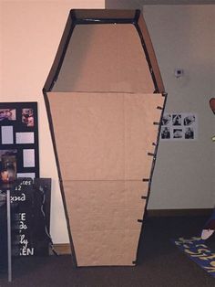 an upside down cardboard box sitting on top of a carpeted floor next to a wall