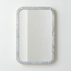 a mirror that is sitting on top of a wall next to a white wall and floor