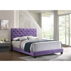 a bed with purple upholstered headboard and foot board, in a bedroom