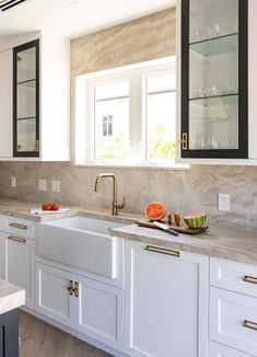 a kitchen with marble counter tops and white cabinets