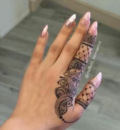 a woman's hand with henna tattoos on it