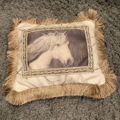 a pillow with a horse on it sitting on top of a gray carpeted floor