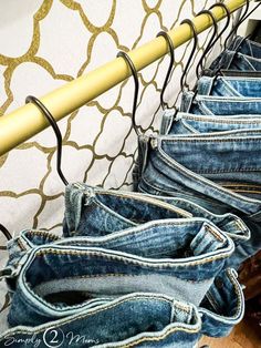 several pairs of jeans hanging on a clothes rack