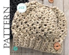 a crocheted hat with buttons is shown on a wooden surface and has the words,