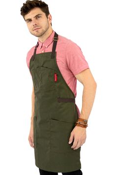 a man wearing an apron and pink shirt is posing for the camera with his hands on his hips