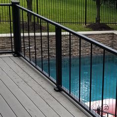 an inflatable raft is sitting on the deck next to a fenced pool