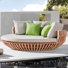 an outdoor daybed with green and white pillows