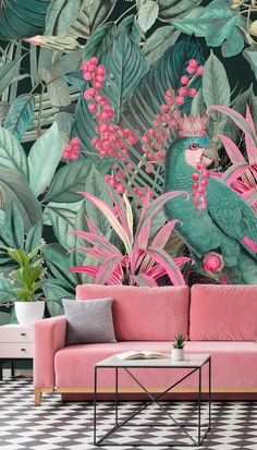 a pink couch sitting in front of a wall mural with green leaves and flowers on it