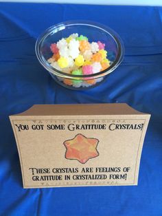 a bowl filled with gummy bears next to a sign that says you got some creature crystals