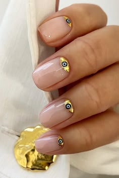 These almond-shaped nails feature a sheer pink base, each accented with an all-seeing eye charm embraced by gold foil details. The design combines understated elegance with a touch of mystical charm. Perfect for those who want a subtle nod to esoteric vibes while keeping it chic and polished. ✨  // Photo Credit: Instagram @bylauren____ Ojo Turco Nails, Eyes Nails, Trendy Manicure, Nails Art Ideas, Squoval Nails, Dot Nail Art