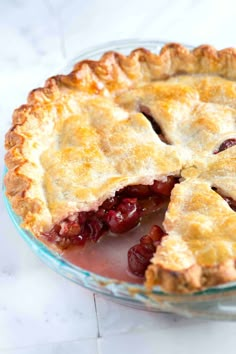 a pie that is sitting in a glass dish on a table and ready to be eaten