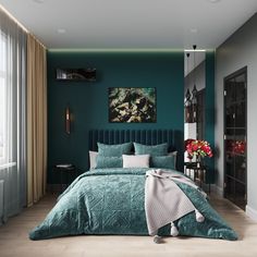 a bedroom with teal colored walls and bedding in the center, along with a painting on the wall