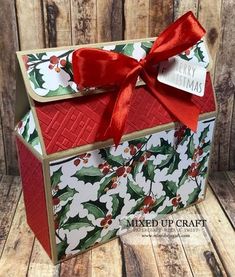 a christmas card box with holly and red ribbon