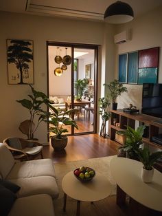 a living room filled with furniture and a flat screen tv sitting on top of a hard wood floor