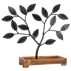 a metal tree with jewelry hanging from it's branches on a wooden stand in front of a white background