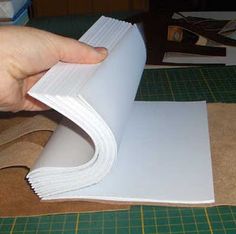 a person is cutting out some paper on a table