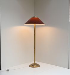 a lamp that is sitting on top of a table next to a wall and window