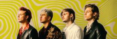 three men standing in front of a yellow and green wall