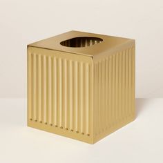 a gold trash can sitting on top of a white table