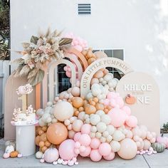 a bunch of balloons that are in front of a building with a sign on it