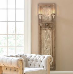 a white chair sitting in front of a window next to a wooden clock on the wall