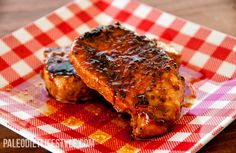 two pieces of meat sitting on top of a red and white checkered plate