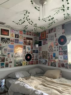 a bed sitting under a ceiling covered in pictures