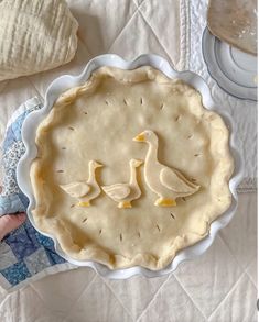 two ducks are sitting on top of a pie crust in the shape of a heart