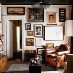 a living room filled with furniture and pictures on the wall