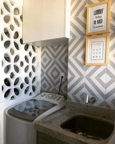 a washer and dryer in a small room with patterned wall paper on the walls