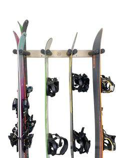 three snowboards are mounted to a wall with skis on it's sides