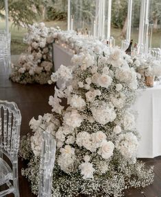 white flowers and candles are arranged on the table for an elegant wedding reception in a glass walled room