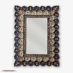 an ornate mirror is hanging on the wall with a black frame and blue trimmings