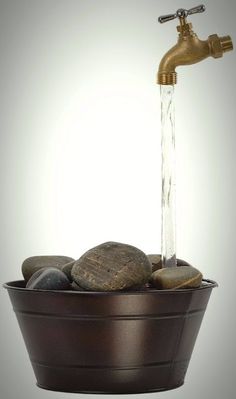 a faucet that has rocks in it and water coming out of the faucet