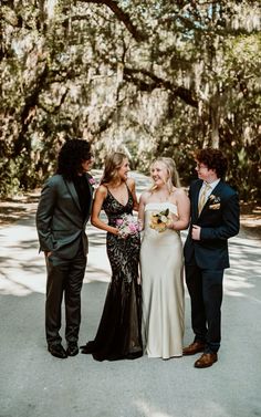 a group of people standing next to each other in front of a tree filled forest