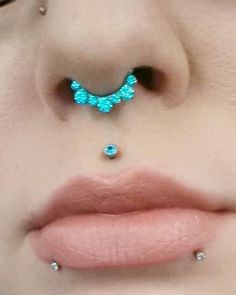 a woman's nose is adorned with blue jewels